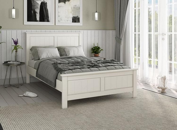 White wooden bed frame against panelled wall